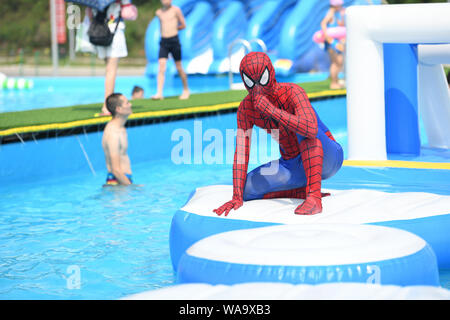 Chinese staff memers dressed as Spider-Man play in a swimming pool during a flash mob event at a water park to escape heat wave in Chongqing, China, 2 Stock Photo