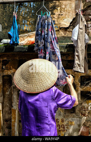 Woman tending clothes on a street in Hanoi, Vietnam. Stock Photo
