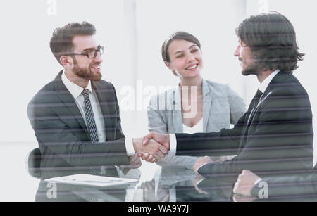 from behind the glass.handshake of business partners Stock Photo