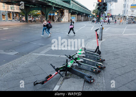 One early morning, recently arrived in Berlin, Uber-owned LIME and VOI e-scooters lay on the pavement, Berlin. Stock Photo
