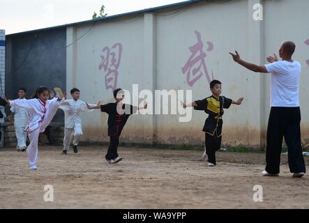 A Chinese child practices Chinese martial arts or kungfu directed by Chen Honglin, a well-known local practitioner, to maintain fitness during the sum Stock Photo