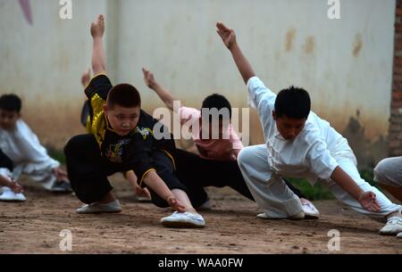 A Chinese child practices Chinese martial arts or kungfu directed by Chen Honglin, a well-known local practitioner, to maintain fitness during the sum Stock Photo