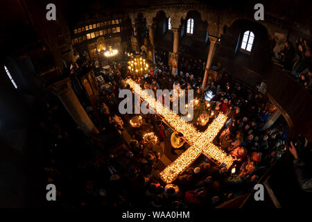 Blagoevgrad, Bulgaria - February 10, 2019: Worshippers light candles on jars with honey during a religious ritual marking the day of Saint Haralampi - Stock Photo