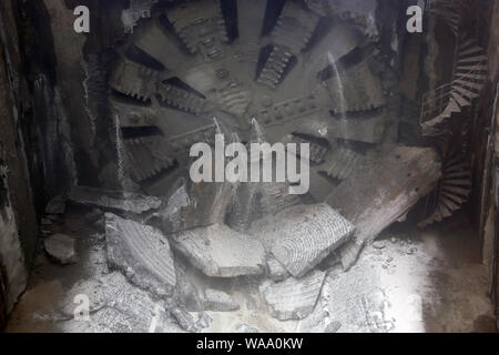 Tunnel Boring Machine front head element is seen rotating on a subway station under construction. Dust and water. Stock Photo