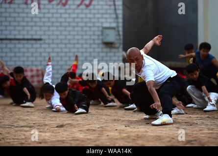 A Chinese child practices Chinese martial arts or kungfu directed by Chen Honglin, a well-known local practitioner, to maintain fitness during the sum Stock Photo