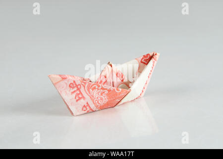 Paper boat of twenty rupee note on white background Stock Photo