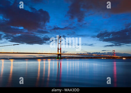 The Humber Bridge over the River Humber after dark at high tide from Barton-upon-Humber in North Lincolnshire, UK Stock Photo