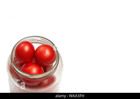 red tomatoes stacked in a secanar jar, preparation for canning. space for content or text Stock Photo