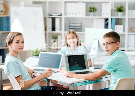 Group of clever middle school students looking at you in classroom Stock Photo