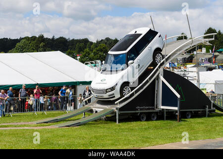 People watch Range Rover Vogue driving down steep descent on scary temporary display course - Land Rover Experience, Great Yorkshire Show, England, UK Stock Photo