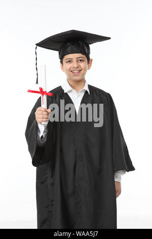 Boy in graduation gown showing a degree Stock Photo