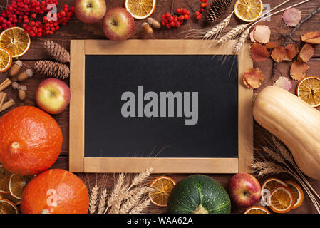 Thanksgiving of harvest fest autumn wooden background with chalkboard decorated with fresh vegetables and fruits. Copy space bright composition Stock Photo