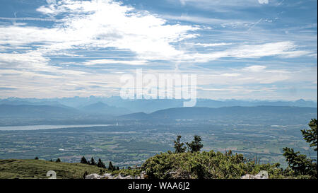 Views of alpine mountain peaks, valleys and lakes on a summer hazy day in Switzerland. Stock Photo