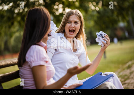 Business colleagues are arguing in park on break. Stock Photo