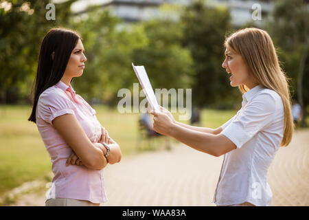 Business colleagues are arguing in park on break. Stock Photo