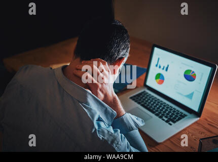 Man working on business project using laptop suffering from neck pain Stock Photo