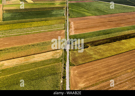 Aerial view of railway through cultivated countryside landscape from drone pov in hot summer afternoon Stock Photo