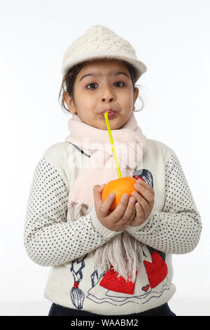 Girl drinking fruit juice with a straw Stock Photo