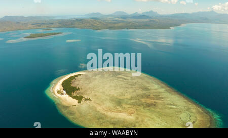 Tropical island and sandy beach with tourists surrounded by coral reef and blue sea in honda bay, aerial view. Island with sand bar and coral reef. starfish island. Summer and travel vacation concept, Philippines, Palawan Stock Photo