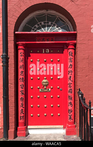 a bright red door in chinatown, liverpool, merseyside, england, britain, uk. Stock Photo