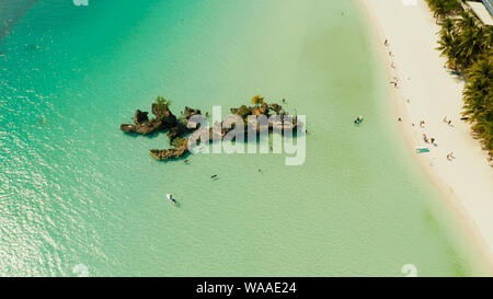 Topical white beach and Willy's rock with tourists and hotels on Boracay Island. Summer and travel vacation concept. Stock Photo