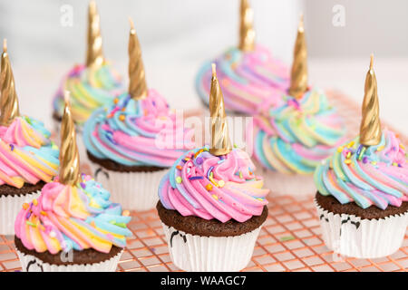 https://l450v.alamy.com/450v/waagc7/decorating-chocolate-unicorn-cupcakes-with-colorful-buttercream-icing-and-sprinkles-waagc7.jpg