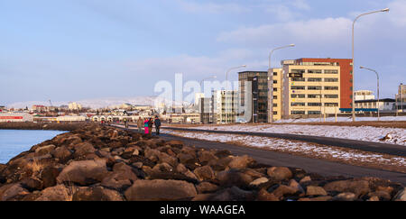 Reykjavik, Iceland - April 3, 2017: Panoramic coastal landscape of Reykjavik, capital city of Iceland. Street view with walking people Stock Photo