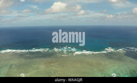 Sea surface with waves against the blue sky with clouds, top view. Blue sea water with waves against sky. Siargao, Philippines. Stock Photo