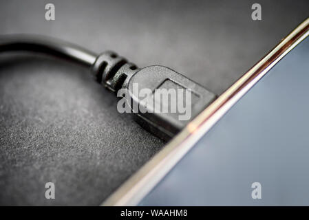 mini usb cable connected to digital tablet closeup view Stock Photo