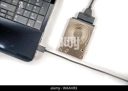 hdd 2.5 internal hard drive disk connected to laptop via sata usb cable closeup view Stock Photo