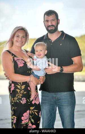 Alicia and Sandy MacDonald with baby Torran, as they celebrate his first birthday with the Bristow Search and Rescue Team at the HM Coastguard helicopter base, Newquay, Cornwall. Stock Photo