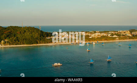 Aerial view of sailing yachts on the sandy beach of Boracay Island at sunset time. Tropical white beach with sailing boat. Summer and travel vacation concept. Stock Photo