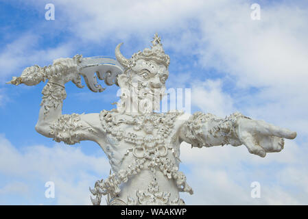 CHIANG RAY, THAILAND - DECEMBER 16, 2018: Sculpture of a demon guarding the entrance to the Buddhist temple Wat Rong Khun (White Temple) close-up Stock Photo