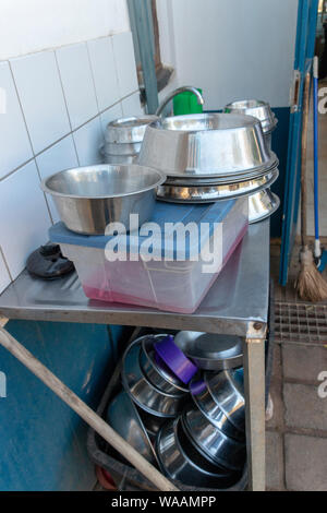 A close up view of metal dogs dishes piled up on a washing sink waiting to be cleaned Stock Photo