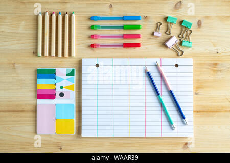 Page of notebook with two pencils and clips, sets of crayons and erasers Stock Photo