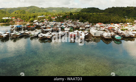 Old wooden house standing on the sea in the fishing village, aerial view. Dapa, Siargao, Philippines. Stock Photo