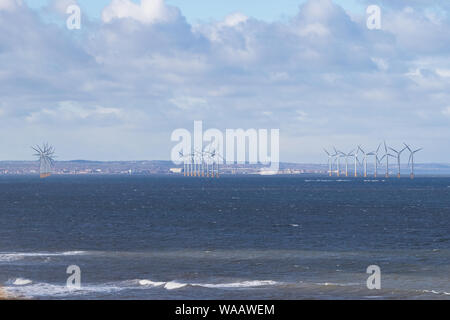 Three sets of wind turbines off the North Sea coast at Redcar, on a fine day. Stock Photo