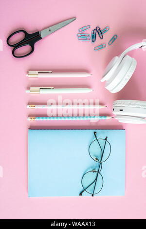 Pens, pencils, clips, scissors, headphones, eyeglasses and blue notebook Stock Photo