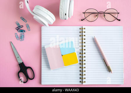 Open notebook, erasers, pen, clips, scissors, eyeglasses and headphones Stock Photo