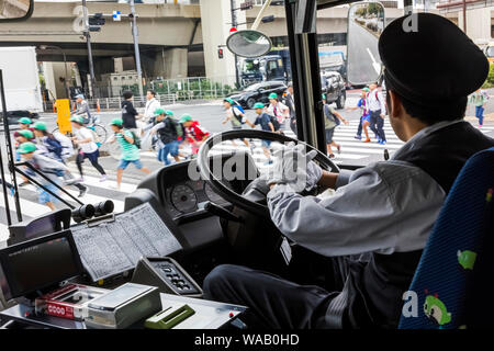 Japan, Honshu, Tokyo, Bus Driver Stopping for Children Crossing Road, 30076297 Stock Photo