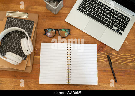 Overview of open notebook with blank pages surrounded by other supplies Stock Photo