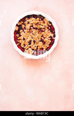 Mixed berry crumble in baking dish on rustic table. Top view, blank space Stock Photo