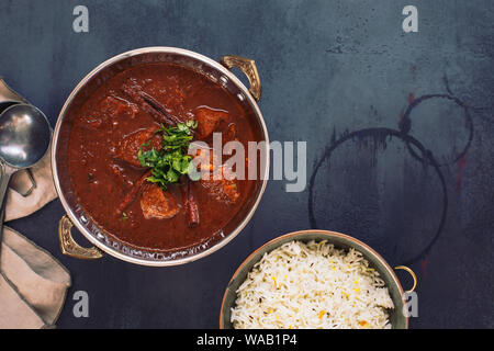 Kashmiri Lamb Rogan Josh. Slow cooked lamb curry served with pulao rice and garnished with coriander. Top view, blank space Stock Photo