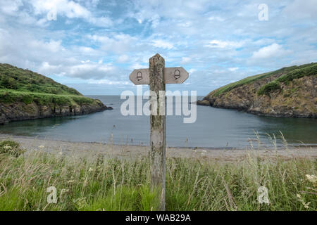 The acorn symbol is the waymark for National hiking trails in England and Wales. This is one of the signs along the Pembrokeshire Coast Path in Wales. Stock Photo