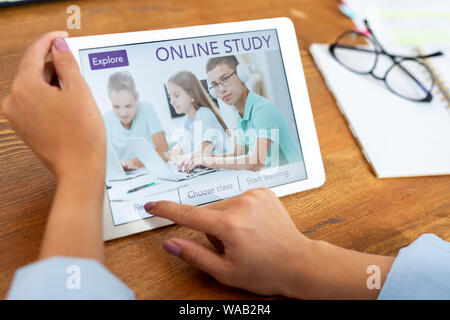Woman pressing button on touchpad display to register on educational website Stock Photo