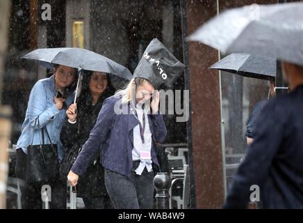 Pic shows: August washout continues as heavy rain and thunder hit Central London in Clerkenwell today.19.8.19  Bag on the head caught out with no umbr Stock Photo