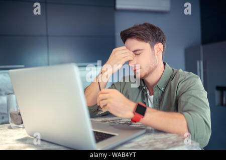Freelancer feeling sleepy while working all day at home Stock Photo