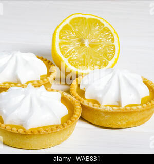 Lemon Meringue Pie. Small Lemon Meringue Pie Dessert Shortcrust Pastry with Lemon Custard Filling and Fluffy Meringue Topping Isolated on a white back Stock Photo