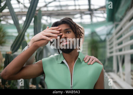 Dark-eyed man posing with blonde man standing behind Stock Photo