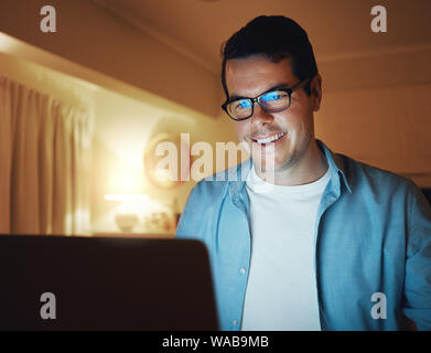 Smiling male freelancer working on the web with laptop Stock Photo